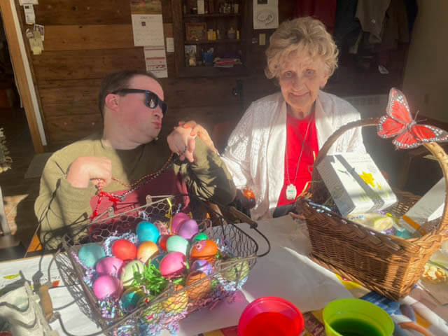 Joanne and friend coloring easter eggs at Ephphatha Farm