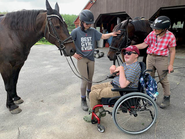A horse at Ephphatha Farms engages with a man in a wheelchair