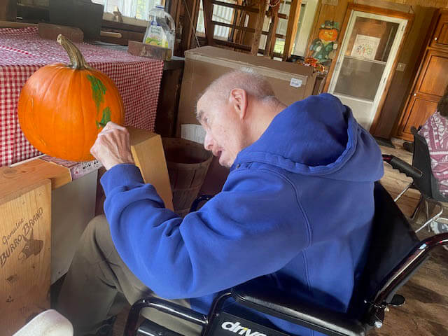 A friend of the farm painting a pumpkin